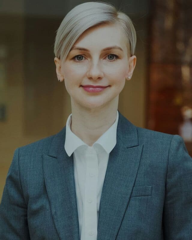 A smiling woman in a grey suit